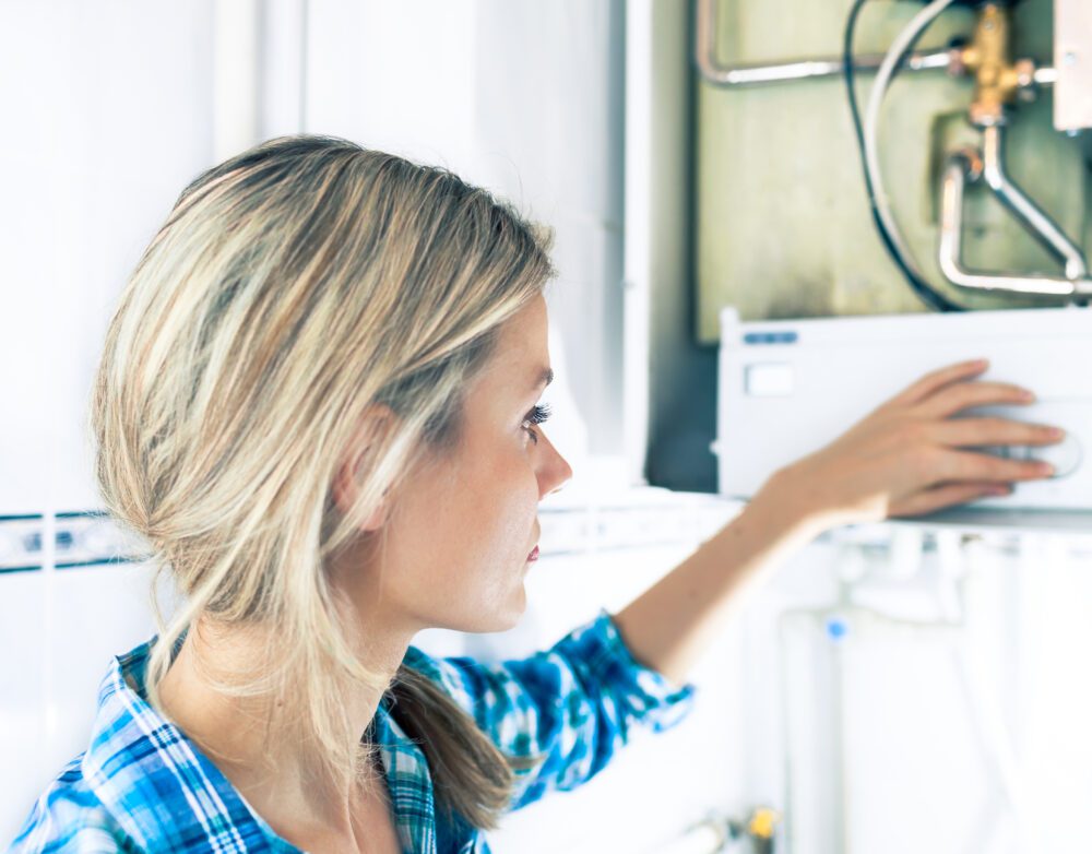 A woman inspects a household boiler during a check up